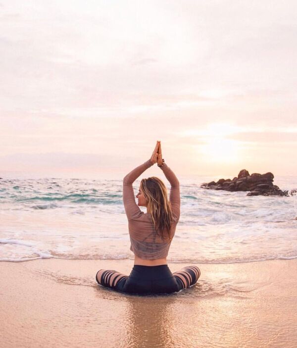 Persona adulta realizando una postura suave de yoga en un espacio luminoso