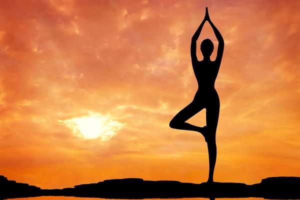Persona adulta sentada en una postura tranquila de meditación al aire libre